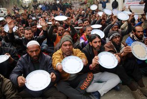 File - Workers hold out empty plates in a symbolic gesture at an Indian Casual Labor Union protest regarding their work demands and rights in Jammu, India.