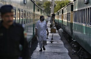 Pakistan railway repairmen examine coaches of a passenger train at a railway station in Rawalpindi, Pakistan