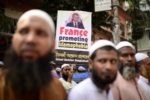 Supporters of Islami Andolan Bangladesh, an Islamist political party, carry a defaced poster of French President Emmanuel Macron as they protest against the publishing of caricatures of the Prophet Muhammad they deem blasphemous, in Dhaka, Bangladesh