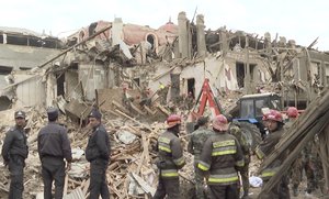 In this photo taken from the Associated Press Television video, rescuers work at the scene of damage after shelling by Armenian's artillery during fighting over the separatist region of Nagorno-Karabakh