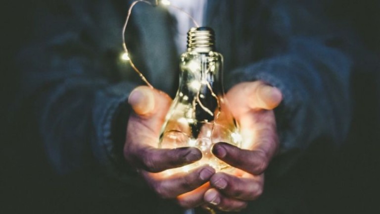 Hands holding a light bulb