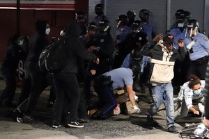 A man, center, is detained by Philadelphia police in Philadelphia, Tuesday, Oct. 27, 2020. Hundreds of demonstrators marched in West Philadelphia over the death of Walter Wallace Jr., a Black man who was killed by police in Philadelphia on Monday. Police shot and killed the 27-year-old on a Philadelphia street after yelling at him to drop his knife.