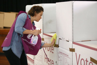 An election official sanitises a polling booth during council elections in March.