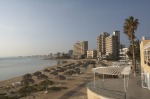 Beach umbrellas on Palm Beach bordering the ghost town of Varosha, abandoned during the Turkish invasion of 1974.