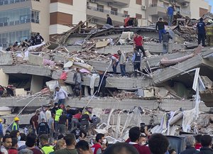 Rescue workers and local people try to save residents trapped in the debris of a collapsed building, in Izmir, Turkey, Friday, Oct. 30, 2020. A strong earthquake struck Friday in the Aegean Sea between the Turkish coast and the Greek island of Samos, collapsing buildings in the city of Izmir in western Turkey.