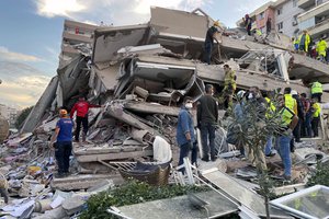 Rescue workers try to save people trapped in the debris of a collapsed building, in Izmir, Turkey, Friday, Oct. 30, 2020. A strong earthquake struck Friday in the Aegean Sea between the Turkish coast and the Greek island of Samos.