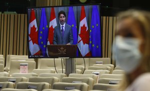 Canadian Prime Minister Justin Trudeau, on screen, participates in a video linked media conference after an EU-Canada summit via video conference at the European Council building in Brussels