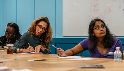 Several women listening to a lecture and taking notes