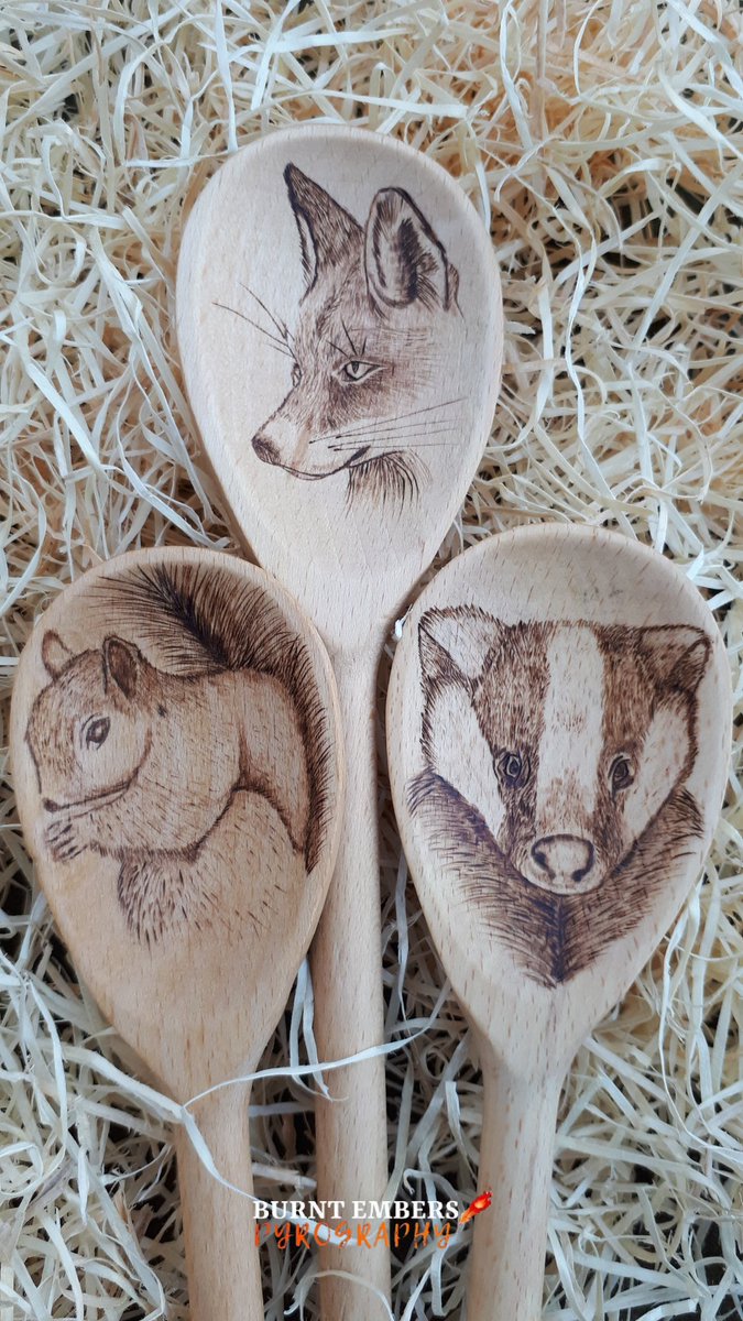 3 wooden spoons, each with a different woodland animal hand burned onto them.  A fox, badger and a squirrel