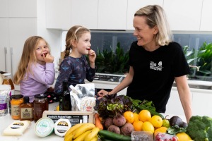 Your Food Collective co-founder Cara Cooper and her children Ella, 3, and Olivia, 6, with a box of fresh produce. 