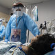 Medical staff wear their photos outside their PPE while checking on a patient at a COVID-19 intensive care unit in Houston, Texas.