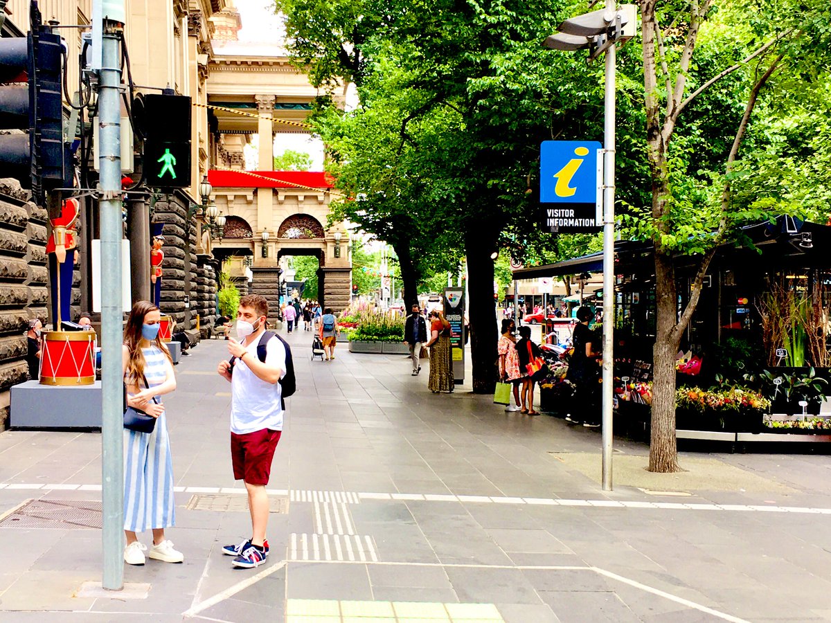 View of Swanston Street Melbourne with Christmas decorations and a few pedestrians visible in masks.