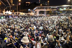 Protesters flash LED lights from their mobile phones during a rally Friday, Nov. 27, 2020 in Bangkok, Thailand