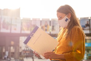 A woman with a face mask holding a "State of the Union 2020" folder, Brussels, Belgium