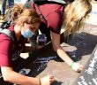 students sign a beam