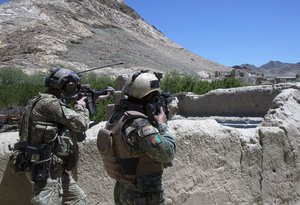 File - An Afghan commando from 8th Special Operations Kandak and a U.S. Special Forces Soldier scan the horizon for enemy movement during an operation to find Taliban leadership in Sayyidabad district, Wardak province, Afghanistan, May 24, 2018.