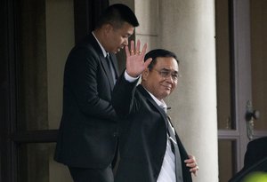 Thailand's Prime Minister Prayuth Chan-o-cha wave to reporter before leave from government house in Bangkok, Thailand, Wednesday, June , 2019.