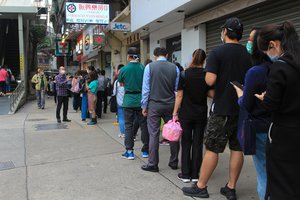 People in Macau, queue up to acquire face masks in a pharmacy, China during Covid-19 pandemic