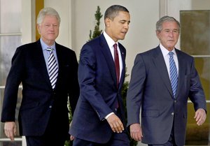 In this Jan. 16, 2010, file photo President Barack Obama, center, walks out of the Oval Office of the White House with former Presidents Bill Clinton, left, and George W. Bush, right, to deliver remarks in the Rose Garden at the White House in Washington