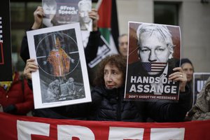 File - Supporters of WikiLeaks founder Julian Assange take part in a protest outside Westminster Magistrates Court in London, to support him in a administrative hearing for his extradition case, Thursday, Nov. 26, 2020.