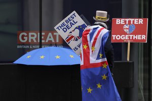 Pro-EU demonstrator Steve Bray props banners outside the conference centre in Westminster where trade talks between the UK and the EU continue in London, Friday, Dec. 4, 2020