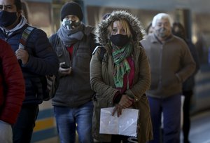 Commuters exit a train station amid the new coronavirus pandemic, in Buenos Aires, Argentina, Friday, June 26, 2020.