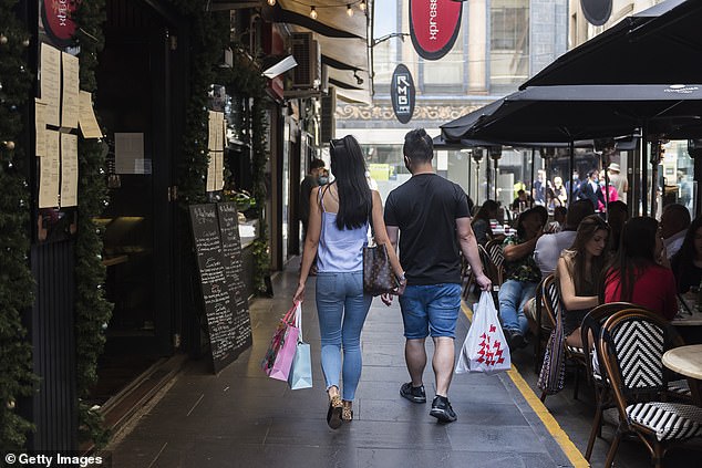 Australia's economy is expected to bounce back from the Covid recession in 2021 as generous tax cuts of $2,445 for average-income earners are brought forward. Pictured are Boxing Day shoppers in Melbourne's city centre