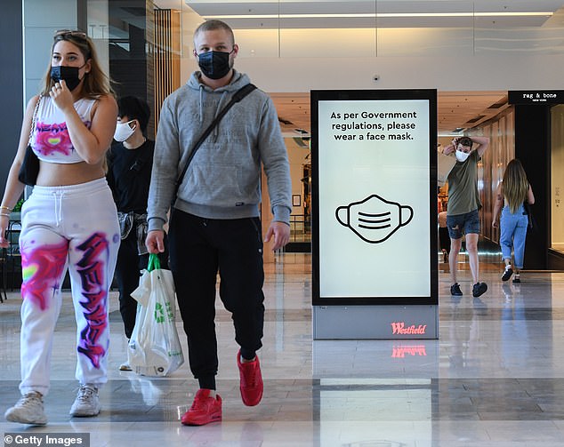 Annoying Covid restrictions and overseas travel bans are likely to continue even as a vaccine is rolled out, Australia's Chief Medical Officer has conceded. Masks have been compulsory in Sydney shopping malls since January 4 . Pictured is Westfield Bondi Junction in the city's east