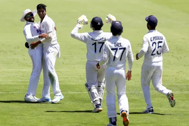 India's Rohit Sharma, left, and teammate Washington Sundar celebrate the dismissal of Australia's Steve Smith during play on the first day of the fourth cricket test between India and Australia at the Gabba, Brisbane, Australia, Friday, Jan. 15, 2021. (AP Photo/Tertius Pickard)