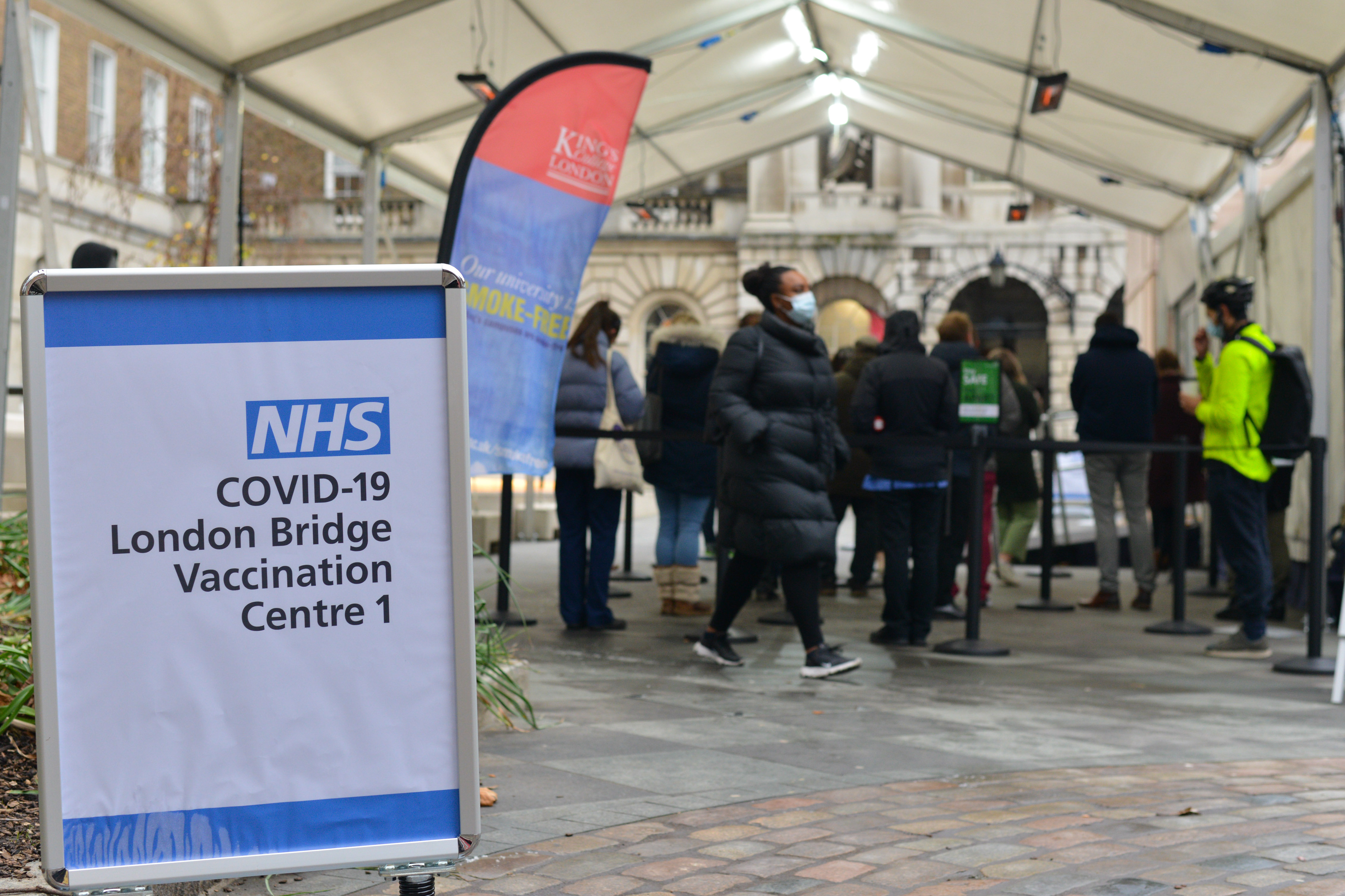 People queue at NHS Covid-19 vaccination centre in London as...