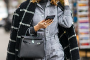 PARIS, FRANCE - FEBRUARY 28: A guest wears a black and white checked pattern plaid long coat, a Hermes bag, a denim jumpsuit, a turtleneck top, outside Ralph & Russo, during Paris Fashion Week - Womenswear Fall/Winter 2020/2021, on February 28, 2020 in Paris, France. (Photo by Edward Berthelot/Getty Images) Get the look: back to the office