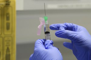 In this Wednesday, Aug. 5, 2020 file photo, senior Clinical Research Nurse Ajithkumar Sukumaran prepares the COVID 19 vaccine to administer to a volunteer, at a clinic in London.