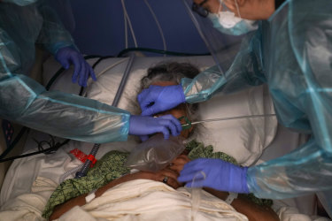 Two nurses put a ventilator on a patient in a COVID-19 unit at St. Joseph Hospital in Orange, California.