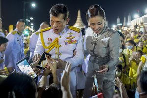 King Maha Vajiralongkorn and Queen Suthida greet supporters in Bangkok, Thailand, Sunday, Nov. 1, 2020. Under increasing pressure from protesters demanding reforms to the monarchy, Thailand's king and queen met Sunday with thousands of adoring supporters in Bangkok, mixing with citizens in the street after attending a religious ceremony inside the Grand Palace