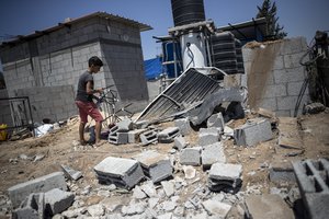 A Palestinian boy inspects the damage in his family home following Israeli airstrikes in Buriej refugee camp, central Gaza Strip, Saturday, Aug. 15, 2020.