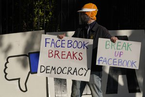 A person demonstrates with others outside of the home of Facebook CEO Mark Zuckerberg as they protest what they say is Facebook spreading disinformation in San Francisco, Saturday, Nov. 21, 2020.