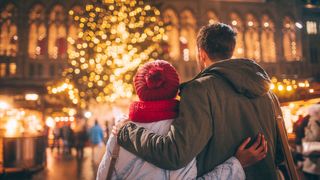 A couple look at a Christmas tree (Credit: Getty Images)