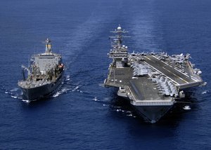 Military Sealift Command fleet replenishment oiler USNS John Lenthall (T-AO 189) cruises alongside the aircraft carrier USS Theodore Roosevelt (CVN 71) during a fueling at sea.