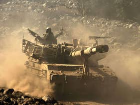 File photo: An Israeli mobile artillery drives through sandy terrain during a military exercise in the Golan Heights, September 19, 2012. 