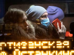 A woman wearing a face mask to help curb the spread of the coronavirus, rides a bus in Moscow, Russia