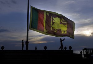 Sri Lankan army soldiers lower the Sri Lankan national flag as the sun sets, in Colombo, Sri Lanka, Sunday, April 11, 2010.