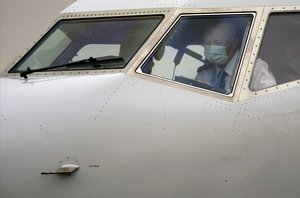 American Airlines pilot captain Pete Gamble, conducts a pre-flight check in the cockpit of a Boeing 737 Max jet before taking off from Dallas Fort Worth airport in Grapevine, Texas, Wednesday, Dec. 2, 2020.