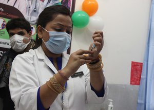 A health worker give a dose at a Government sub hospital as COVID -19 vaccination drive starts in Srinagar, India, 16 January 2021.