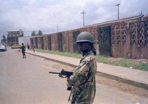 File - Government soldiers patrol the streets of Monrovia outside the Barclay Training Center, June 6, 1990. U.S. Marines are waiting off the coast of Liberia in case they are needed to evacuate Americans from that nation's civil war.