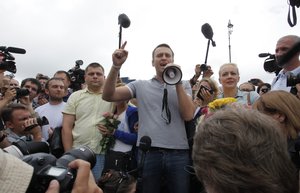 Russian opposition leader Alexei Navalny, foreground center, his wife Yulia, center right, and his former colleague Pyotr Ofitserov, center left, address supporters and journalists after arriving from Kirov at a railway station in Moscow, Russia, Saturday, July 20, 2013