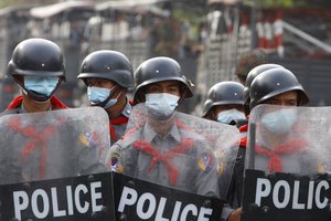 Police security stand guard behind a road barricade in Mandalay, Myanmar Friday, Feb. 19, 2021.