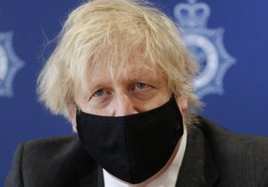 Britain's Prime Minister Boris Johnson listens during a visit to South Wales Police Headquarters in Bridgend in Wales, Wednesday, Feb. 17, 2021. (AP Photo/Alastair Grant, pool)