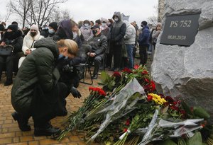 People lay flowers to a memorial in Kyiv, Ukraine, Friday, Jan. 8, 2021, for the victims of a Ukrainian 737-800 plane crash on the outskirts of Tehran.