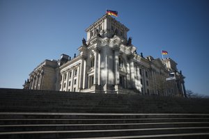 In this Wednesday, March 25, 2020 file photo, reflections of the sun shine on the Reichstag building of the German parliament Bundestag in Berlin