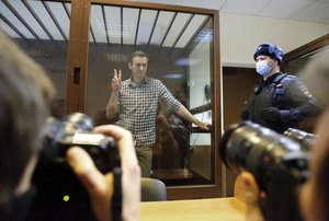 Russian opposition leader Alexei Navalny stands in a cage in the Babuskinsky District Court in Moscow, Russia, Saturday, Feb. 20, 2021